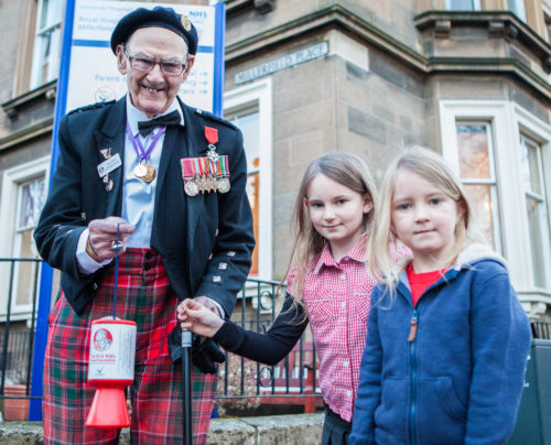 Edinburgh-born war veteran Tom Gilzean (95) has been helping to raise money on the streets of Edinburgh for The Sick Kids Friends Foundation for 33 years. And now needs help to repair his wheelchair so he can continue his charity work. IN PIC (LtoR): Tom Gilzean, Eve (8) and Anabel Watson (5)