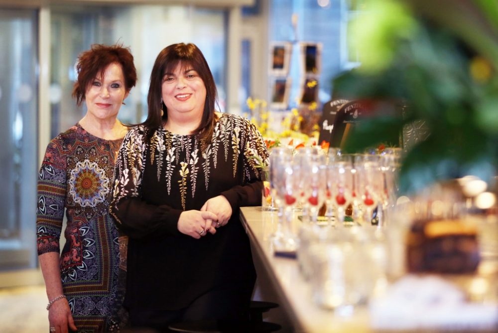 Two ladies stand by the bar