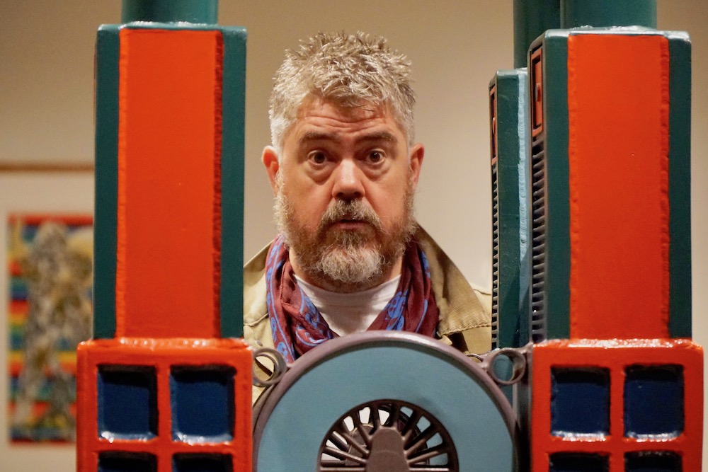 Phill Jupitus behind Paolozzi sculpture