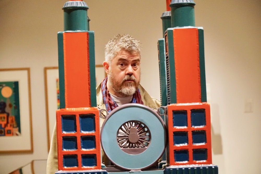 Phill Jupitus behind the Four Towers by Paolozzi