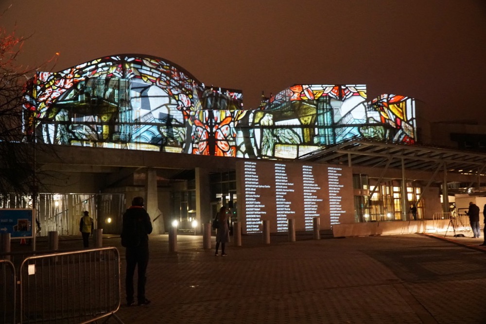 Scottish Parliament with projections illuminating the facade