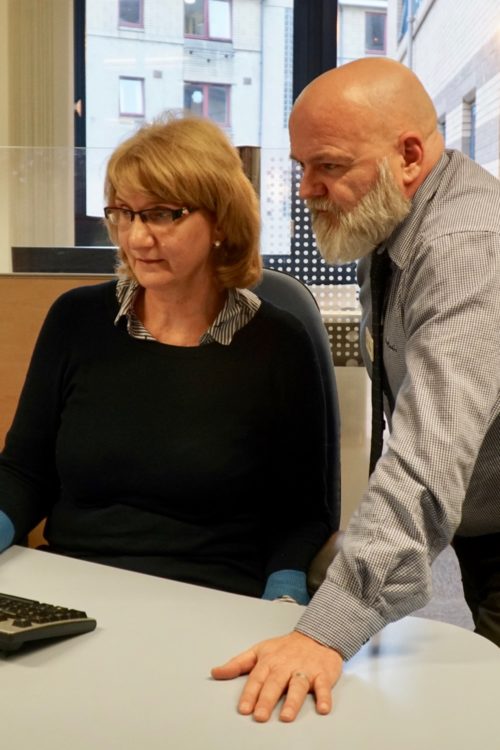 Two DWP employees in their office at a computer