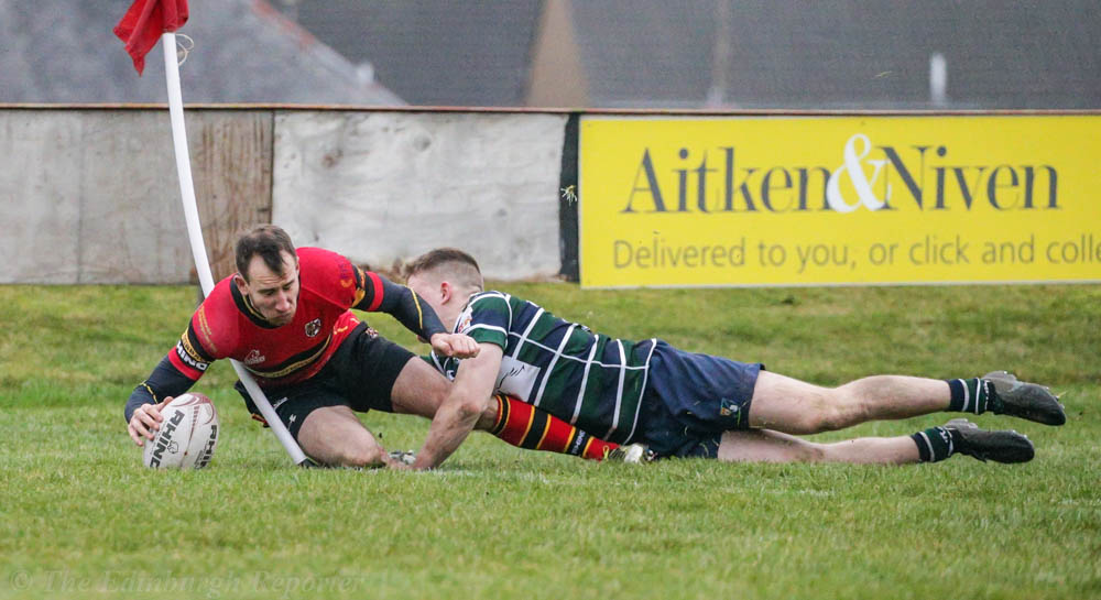 Player in red scoring a try
