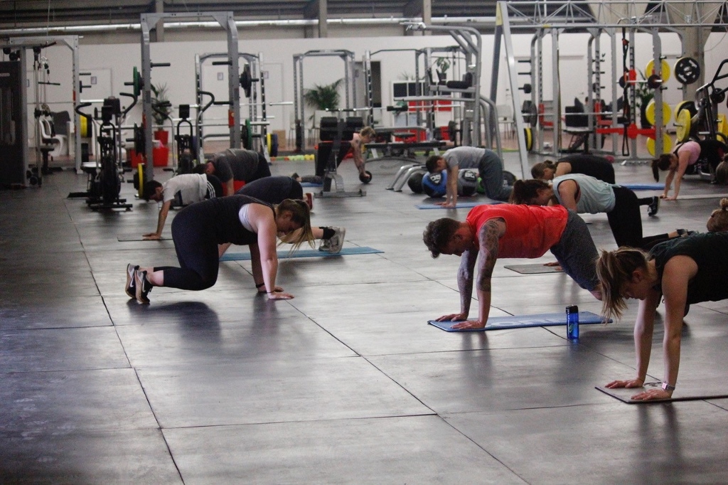 A group of people training hard on floor mats at the gym